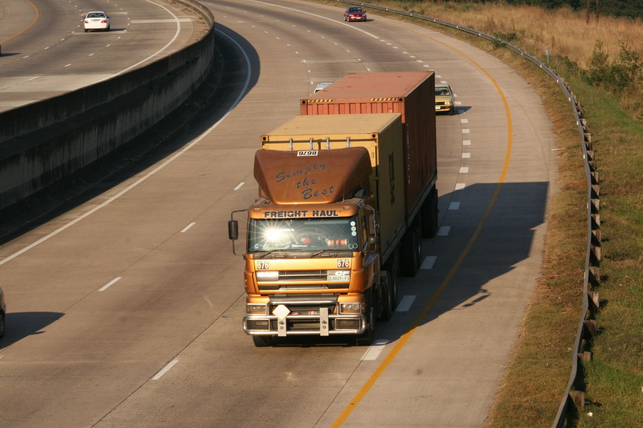 gallery-02 Cargo truck navigating a highway, aerial view on Dolphin Coast, South Africa.