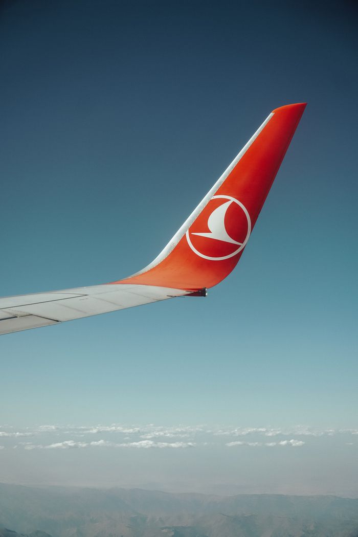 Close-up of airplane winglet against clear sky, showcasing aviation travel.