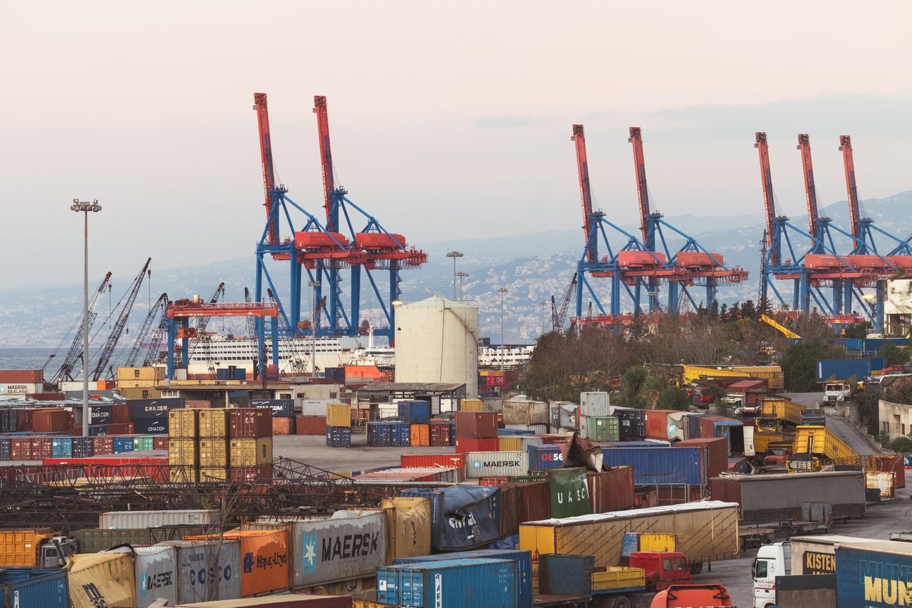 gallery-01 A bustling industrial view of Beirut port with cargo containers and towering cranes.